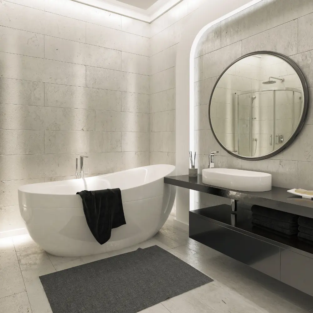 Grande baignoire ovale avec vasque moderne et miroir rond dans une salle de bain en pierre élégante à Mâcon