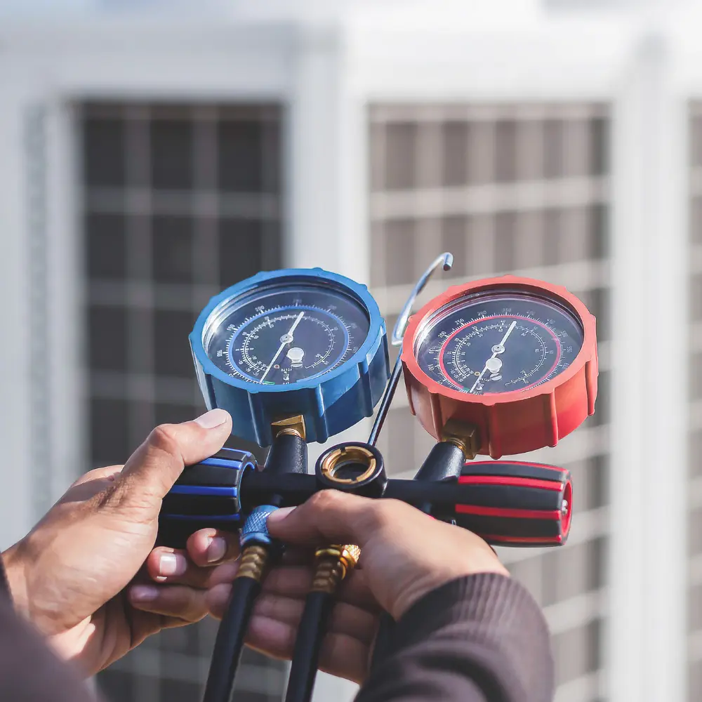 Frigoriste à Mâcon utilisant des instruments de mesure pour l'entretien et le diagnostic d'un système de réfrigération.